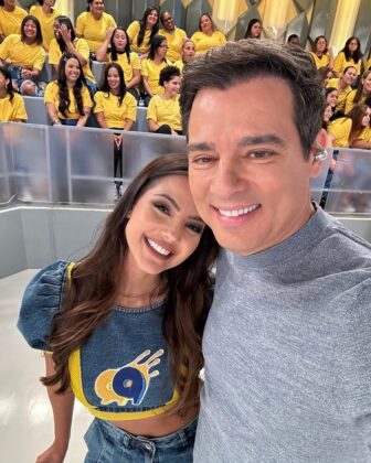 Luana está de camiseta azul sorrindo para a selfei com Celso Portiolli, que está com camiseta cinza