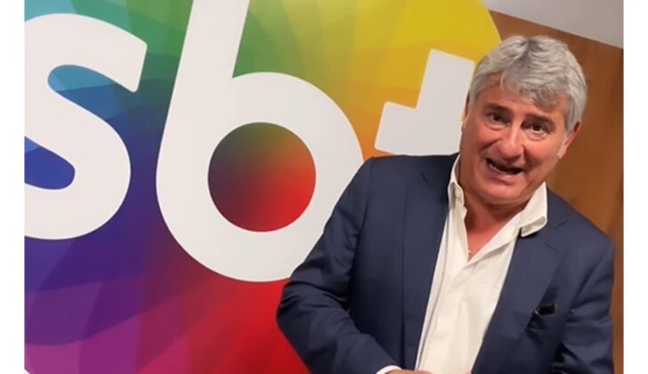 Cleber Machado à frente do logotipo do SBT