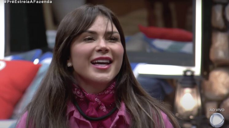 Nadja Pessoa está sorrindo usando uma roupa e lenço rosa.