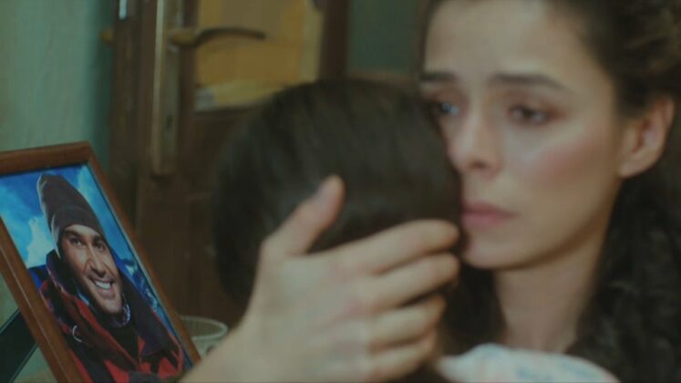 Cena de Força de Mulher com Bahar em destaque com filho nos braços