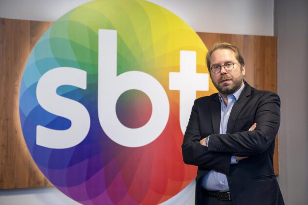 Fernando Fischer à frente do logo do SBT