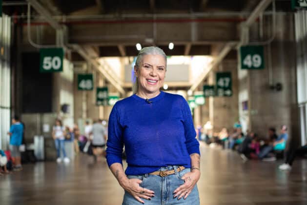 Astrid Fontenelle no saguão do aeroporto com camiseta azul