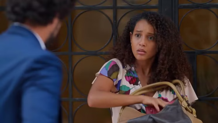 Raquel segura a bolsa roubada que Ivan a devolveu