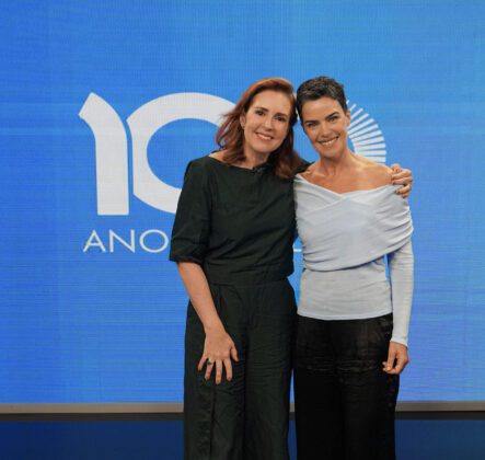 Renata Capucci e Ana Paula Arósio à frente do cenário azul com logo dos 100 anos do grupo Globo