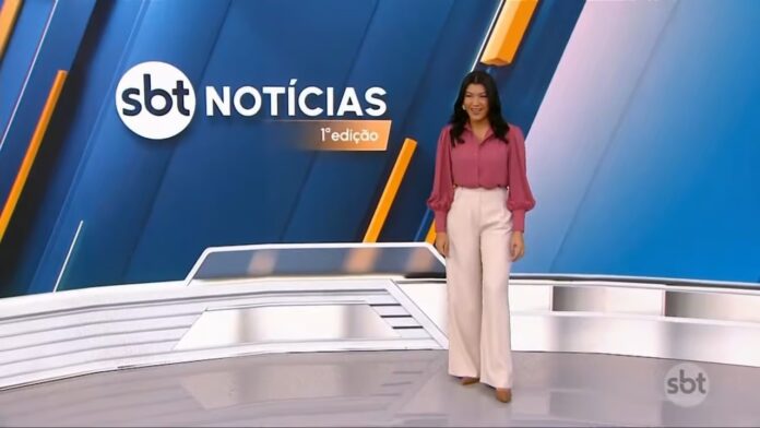 Dani Brandi à frente do telão do SBT Notícias